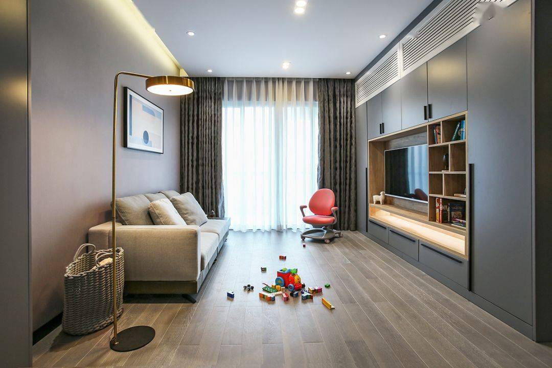 今天分享的是一套建筑面積102平米的現代輕奢風三居室案例，屋主夫妻和女兒、母親一家四口人居住，整體來說是比較緊湊的剛需三房案例，設計師以輕松、時尚的灰色調作為主色，搭配格調滿滿的木質家具，營造出簡約、輕奢的感覺。    平面布置圖    入戶玄關和餐廳連在了一起，利用了入戶門側方的墻面來做上一整墻的柜子，把鞋柜和餐邊柜結合在一起使用，更為省空間。    復古的木質餐桌椅到灰色調的背景，金屬質感的吊燈，整個餐廳看起來非常有格調感。在餐桌椅側方加上隔板的設計，增強儲物能力。    位于餐廳另一側的就是客廳空間了，客廳的茶幾被舍棄，中間留空方便作為孩子的娛樂區，米色布藝沙發和暖灰色背景墻讓人感覺更加溫馨。    客廳的電視背景墻則是被利用起來做了收納，整墻的柜子留空電視周邊的部分區域，加上藏光之后使用更方便，看起來也更大氣。    廚房內部的櫥柜延續了客餐廳的柜子顏色，深灰色的大理石墻磚搭配灰色的啞光地磚，整個廚房看起來很有現代感。    臥室選擇了以藍灰色為主，在臥室頂部吊頂內加上藏光，用吊燈、臺燈等代替主燈，讓臥室看起來更為簡潔。    在主臥室里還有一個迷你的衣帽間，U字形布局的柜子把角落空間充分用上。衣帽間外的床頭柜改成了梳妝臺，使用起來更加方便。    老人房選擇了榻榻米床組合衣柜和書桌的設計，榻榻米的安全性會更高一些，加上一張書桌也方便屋主母親看看書。    衛生間內部是三角形的布局方案，鉆石形的淋浴房做在了轉角處，兩側擺放洗手臺和馬桶。洗手臺上方的鏡柜做了藏光的設計，看起來更時尚。